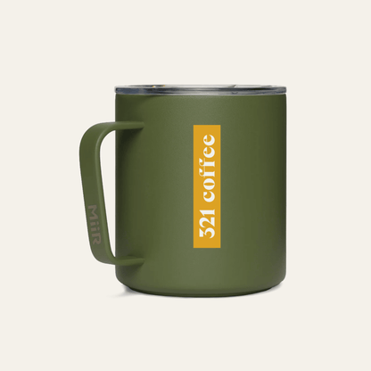 The back of a dark green metal camp mug with "321 Coffee" printed in white on a yellow background on the mug.