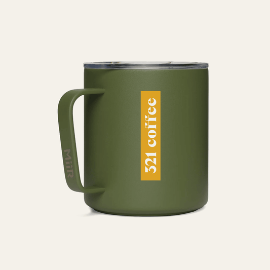 The back of a dark green metal camp mug with "321 Coffee" printed in white on a yellow background on the mug.