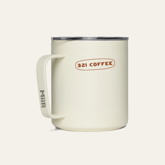 The back of a light beige metal camp mug with "321 Coffee" printed in maroon.
