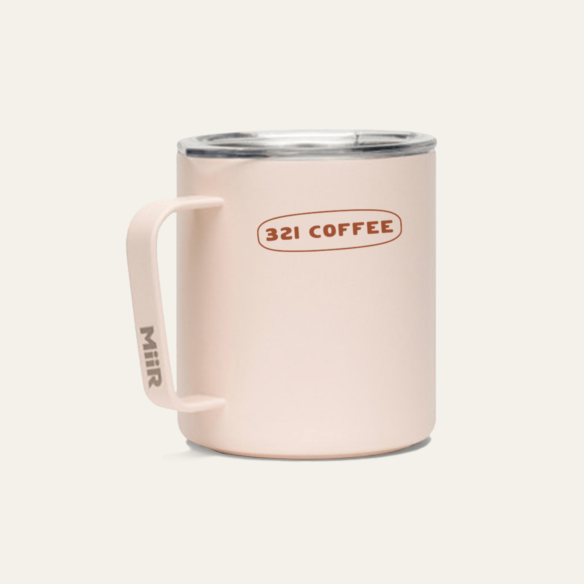The back of a light pink metal camp mug with "321 Coffee" printed in red on the mug.
