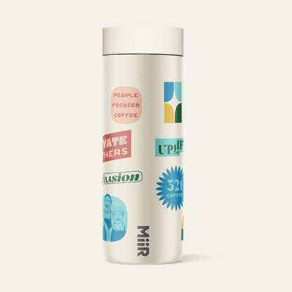 The right side view of 321 Coffee's tumbler. The tumbler is beige and contains elements of 321 Coffee branding, such as sayings like "Rise Up" and "Love Big". The branding is very colorful.