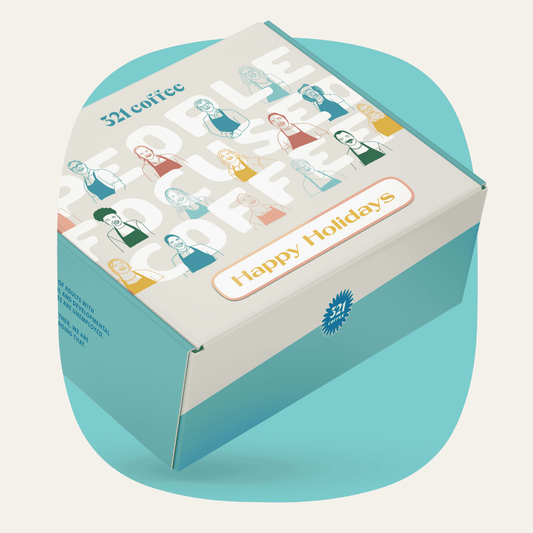 A gift box with colorful sketches of 321 Coffee baristas, "321 Coffee" written on the top, and "Happy Holidays" written on the bottom of the box.