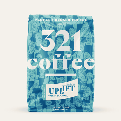 Front view of 321 Coffee's Uplift 5 lb coffee bag. A blue logo reading "321 Coffee" sits on a background of sketches of 321's barista team. The coffee name, Uplift, and information about the beans are shown on a sticker on the bag.